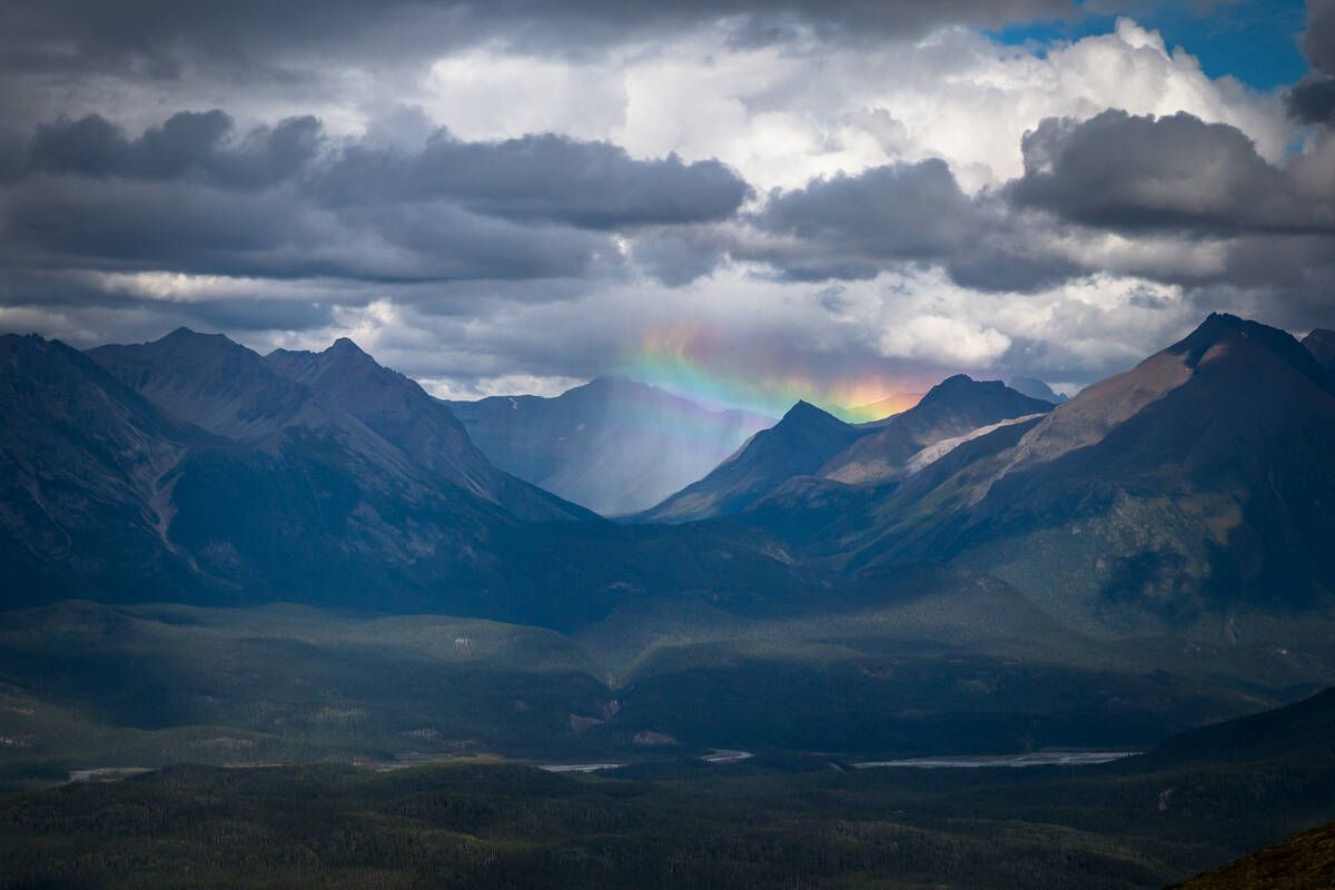 <p>A vibrant rainbow arches over rugged mountain peaks in Dune Za Keyih Park, casting color across dramatic clouds and wild terrain. The scene captures nature’s quiet power and breathtaking beauty. Courtesy of Destination BC</p>