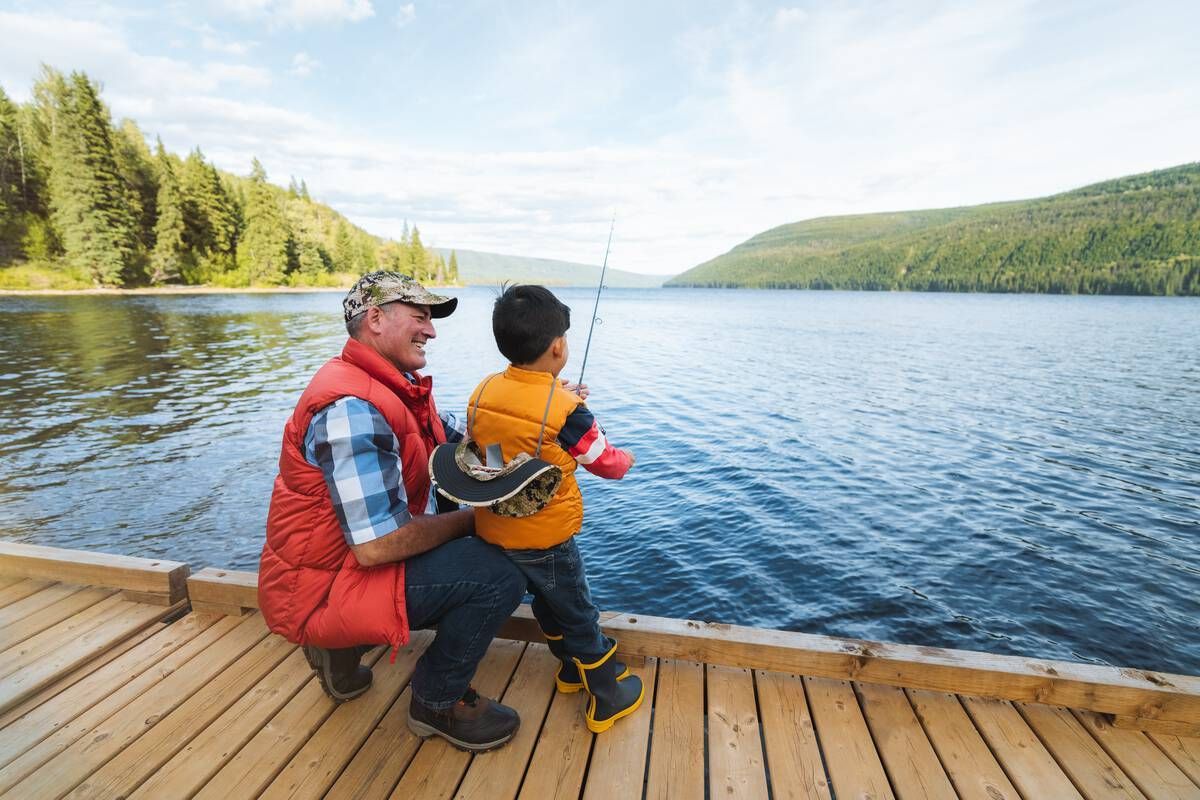 Under a watchful eye, a young angler learns to fish from a dock at Gwillim Lake Park, surrounded by the beauty of nature. Photo courtesy of Destination BC.
