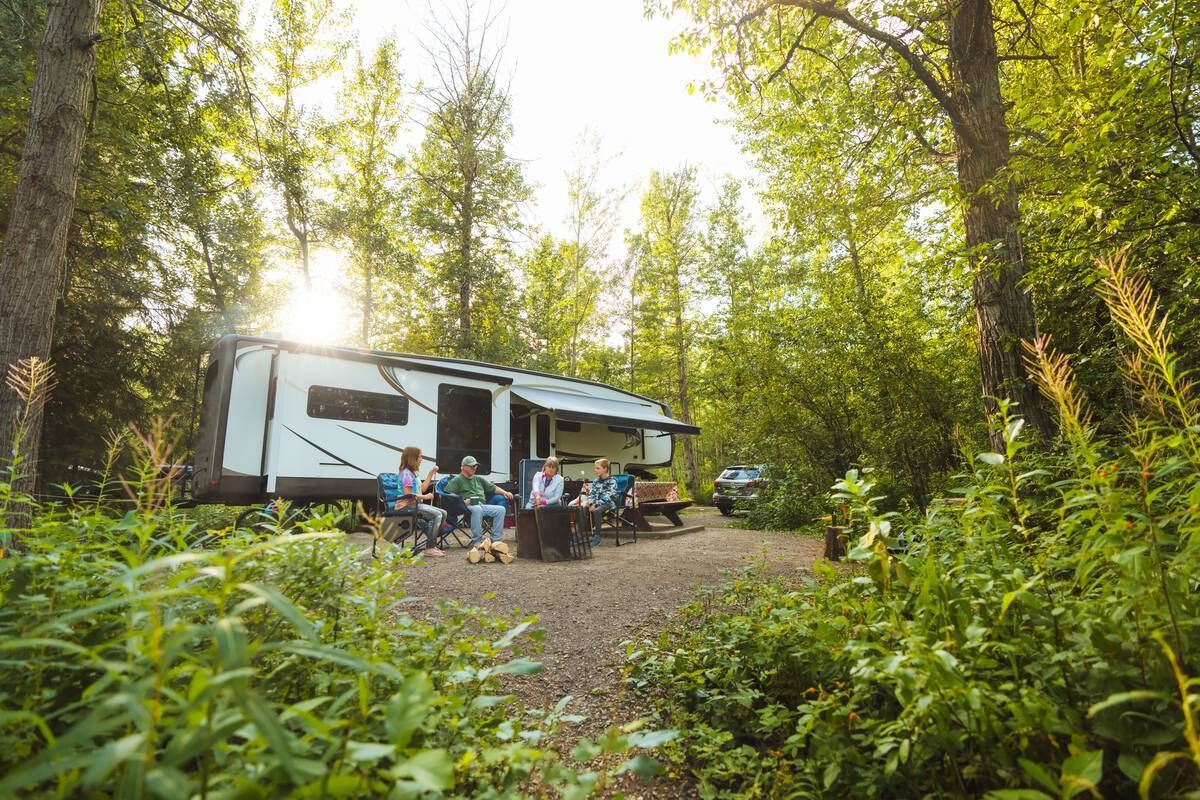 Friends enjoy a large private campsite surrounded by lush forest in Gwillim Lake Park. Courtesy of Destination BC