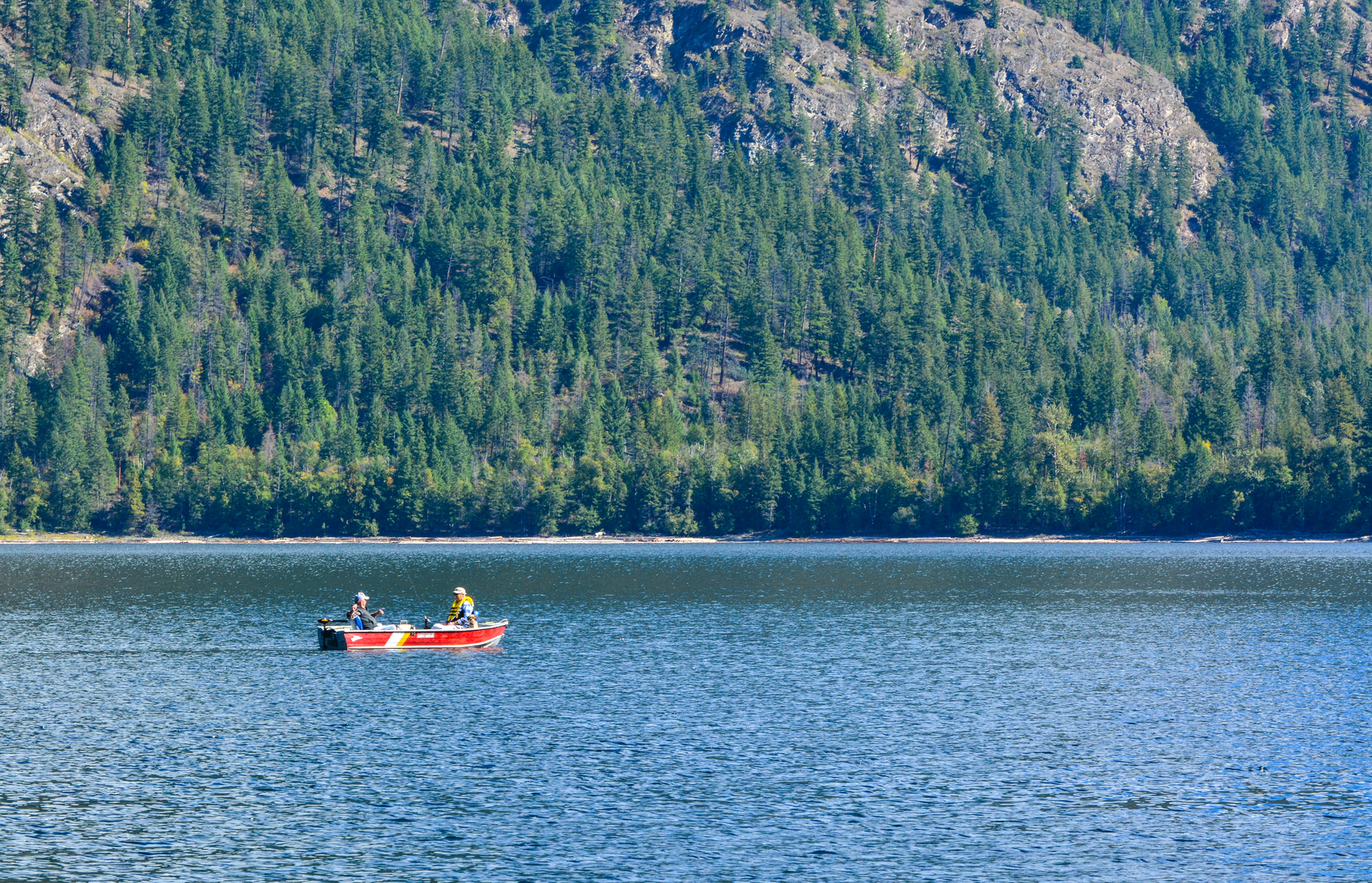 Parks visitors fishing from a boat on Adams Lake Park.