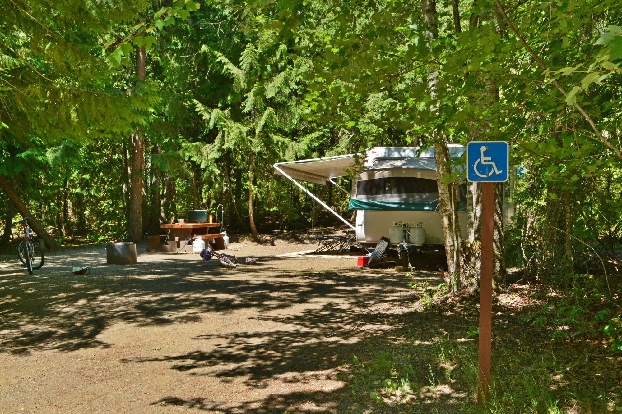 Designated accessible campsite is wide, firm and level throughout. The picnic table has an accessible overhanging. Shuswap Lake Park.