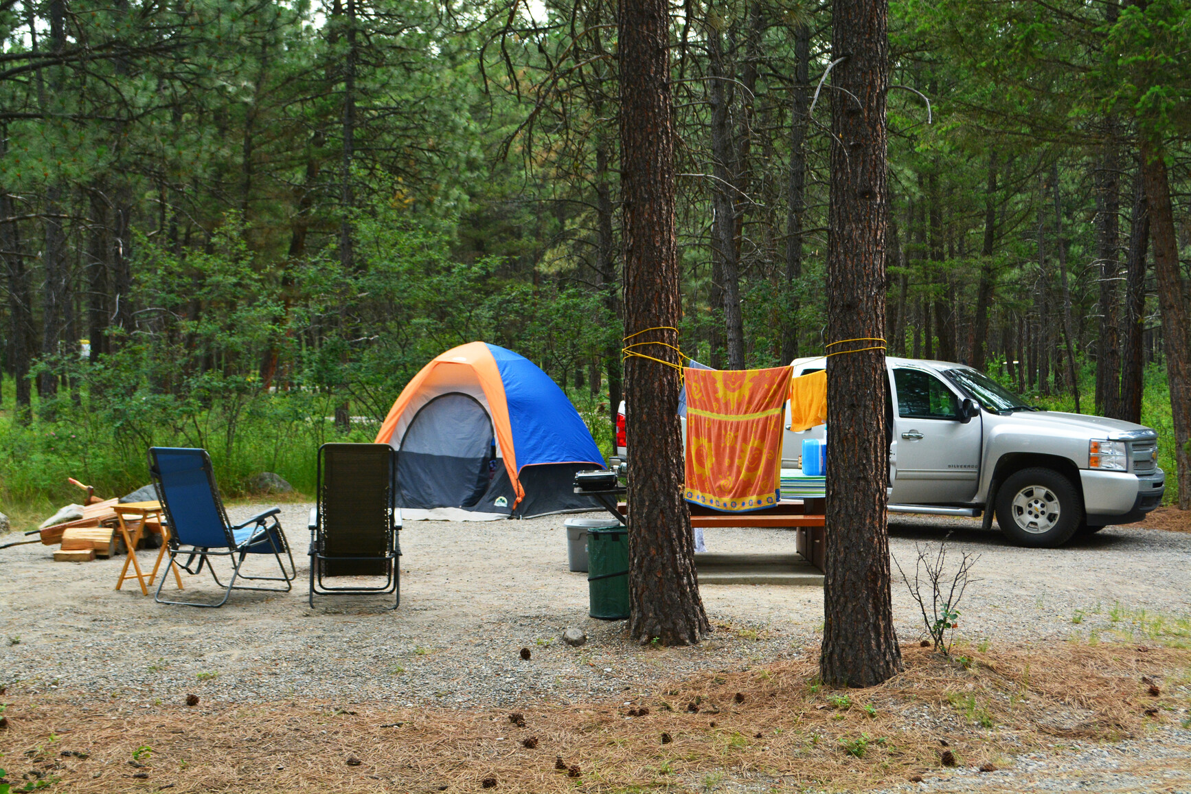 Campsite with a tent. The campground is in the forest.