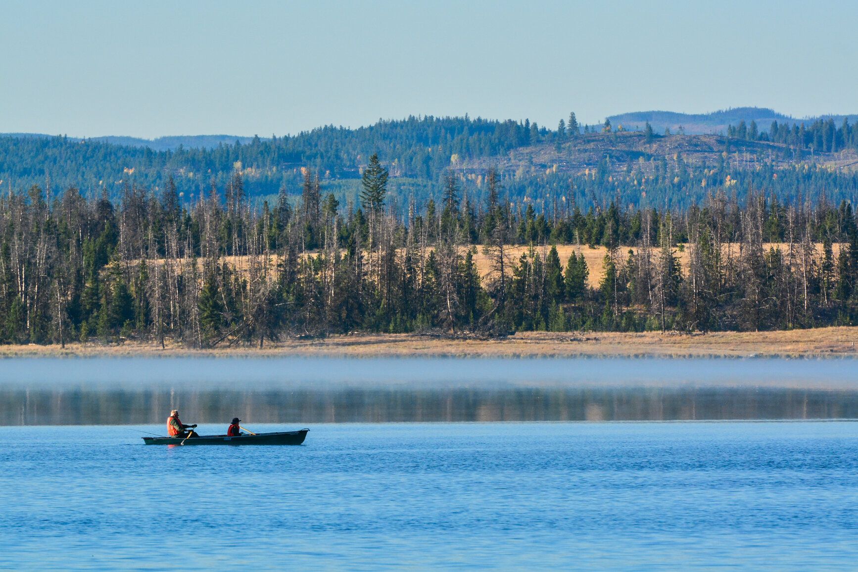 Tunkwa Lake - People canoeing on the lake. Mountains and forest are in the background.