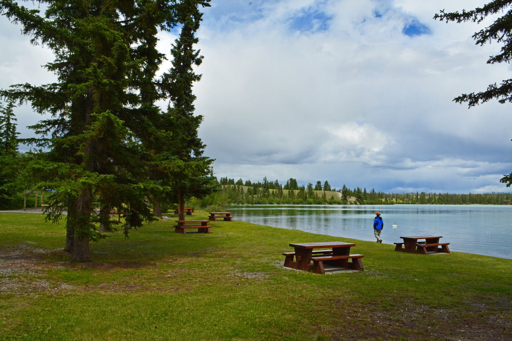 A park visitor walks the shore of Big Bar Lake near the day-use area.