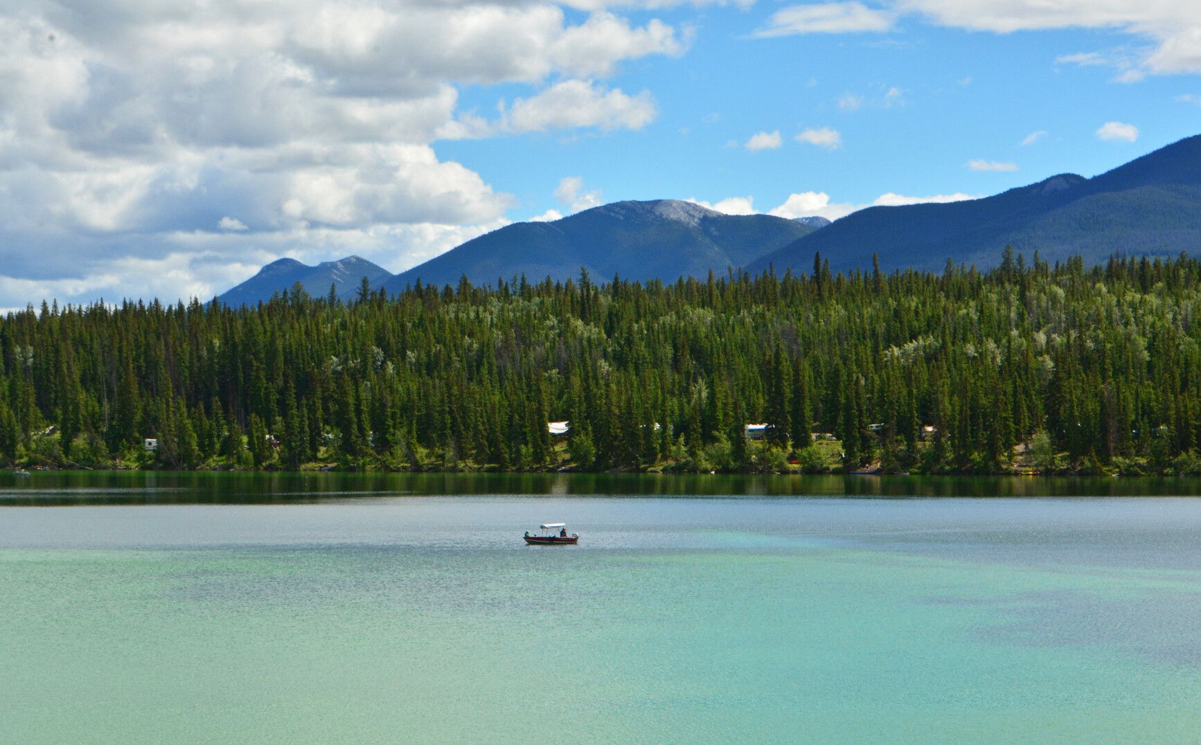 Mountains and forest surrounding Big Bar Lake on a clear summer day.