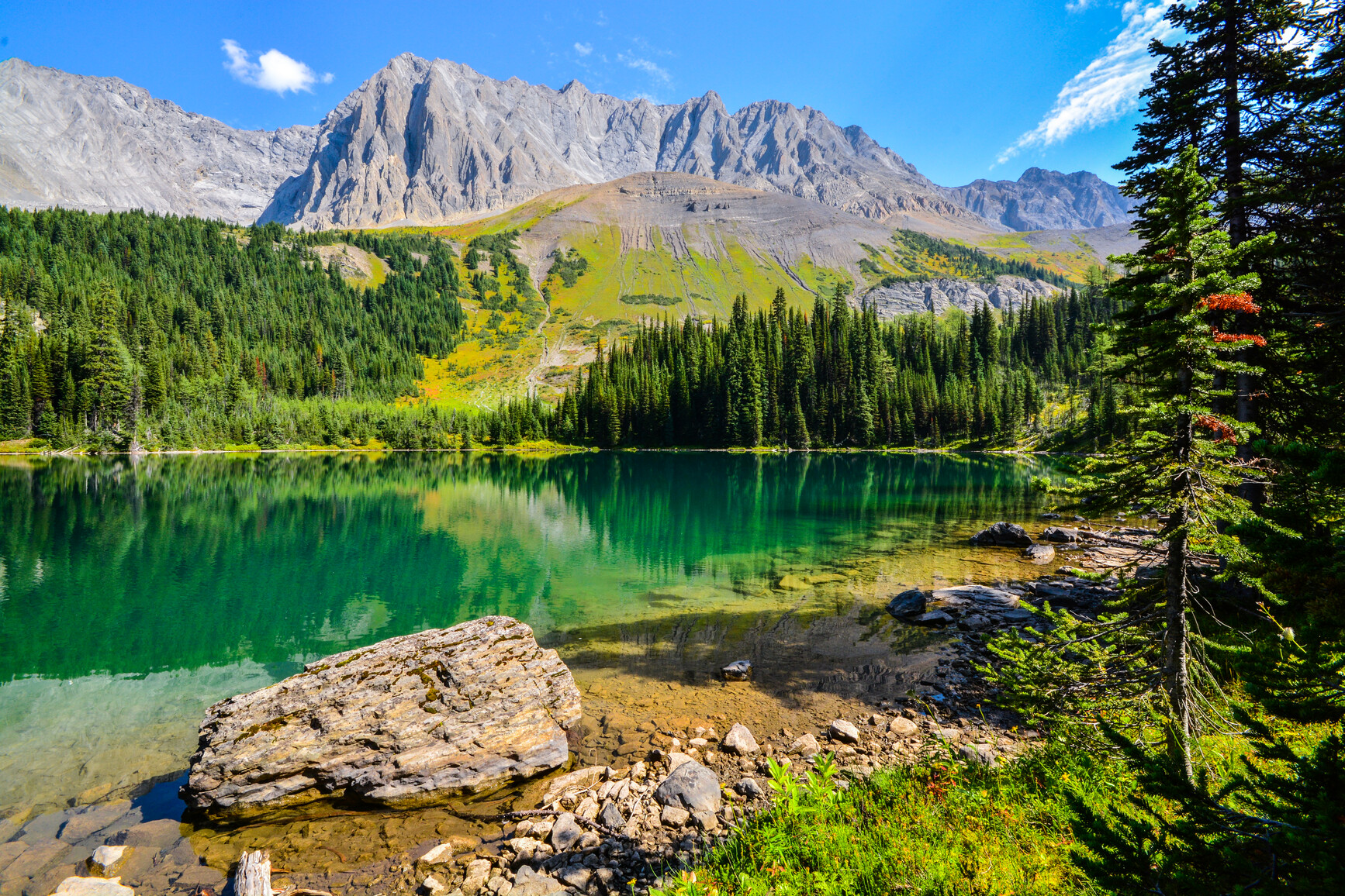 Rugged mountains and forest surrounding Beatty Lake reflect on it's surface. Height of the Rockies Park.