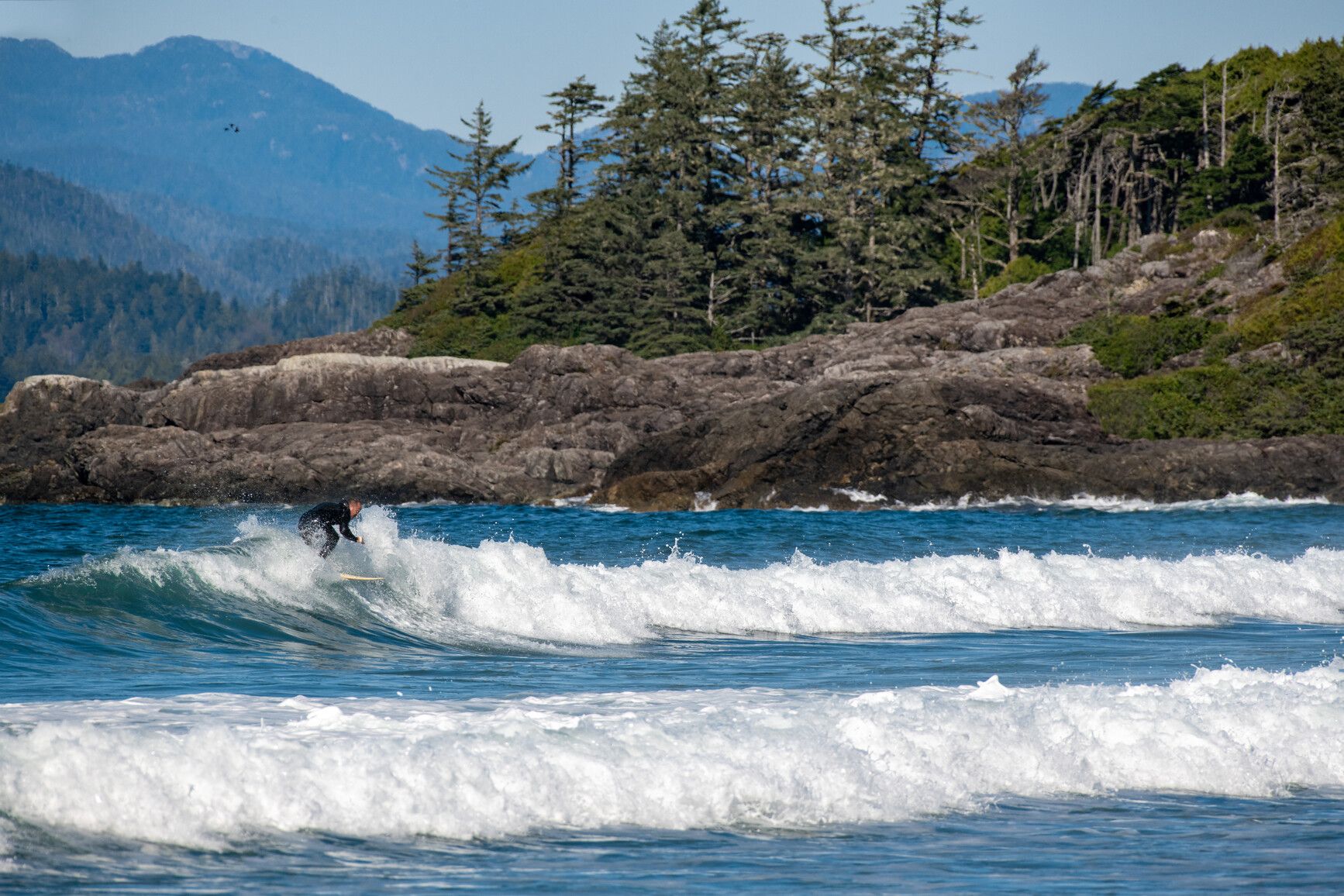 A surfer catches a wave on the ocean just off Vargas Island Park.