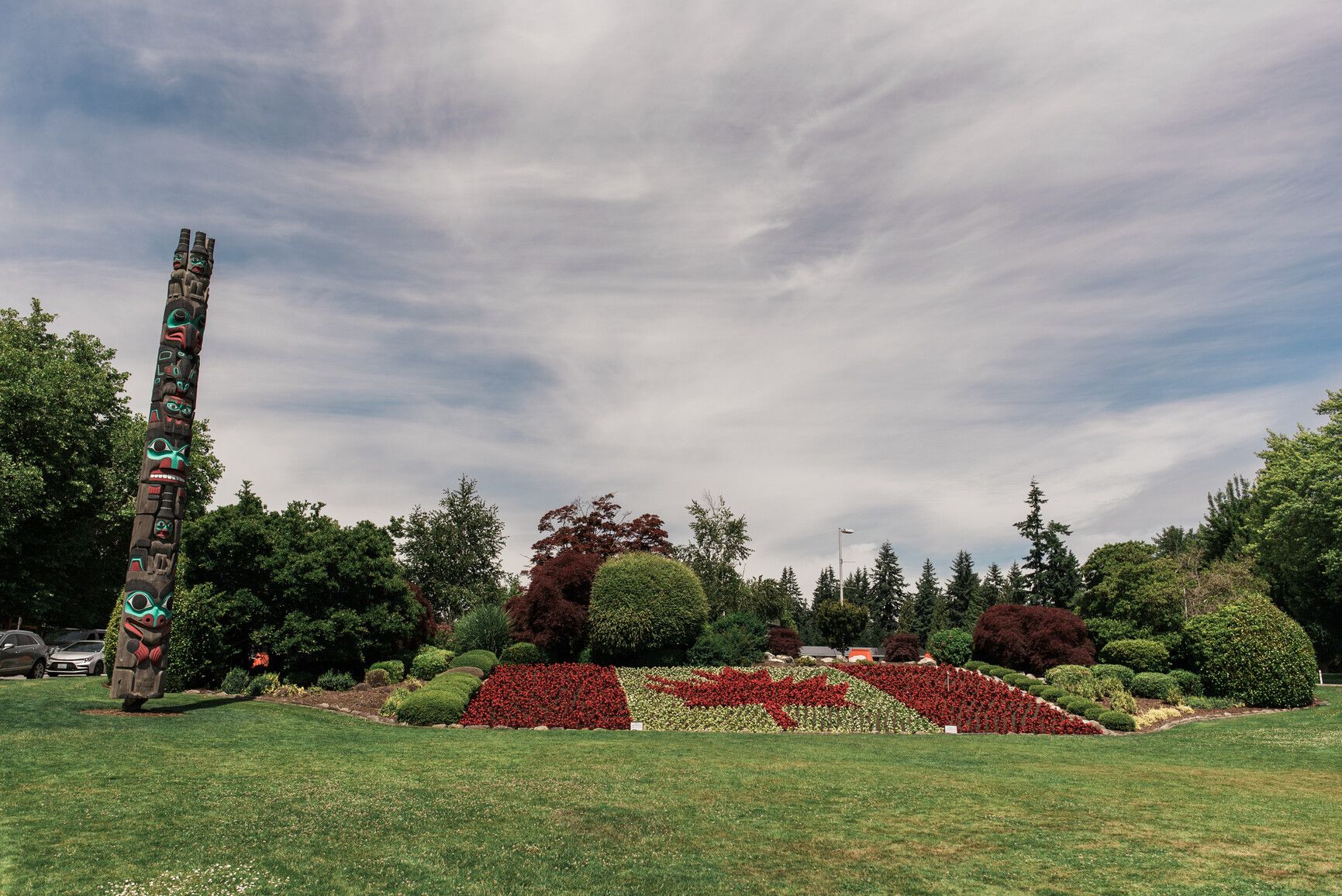 The floral garden in Peace Arch Park with a totem pole and Canadian flag made from flowers.