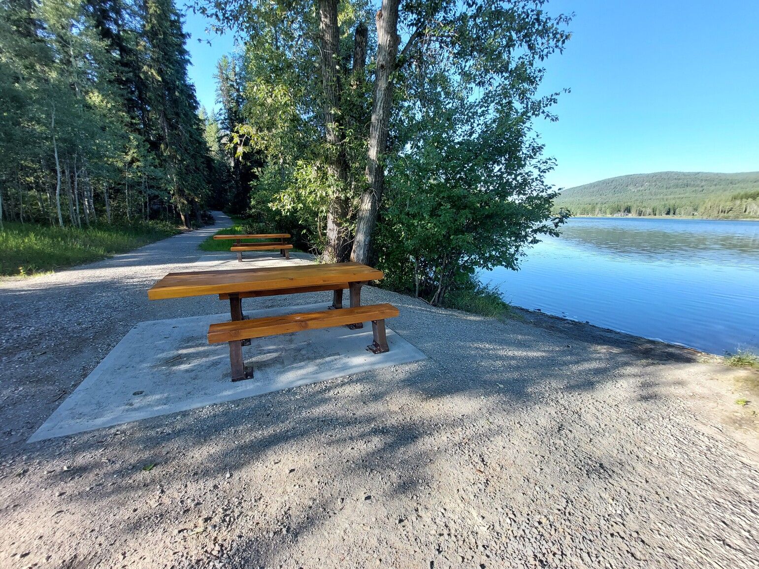 Picnic tables in the day-use area beside the lake at Jimsmith Lake Park.