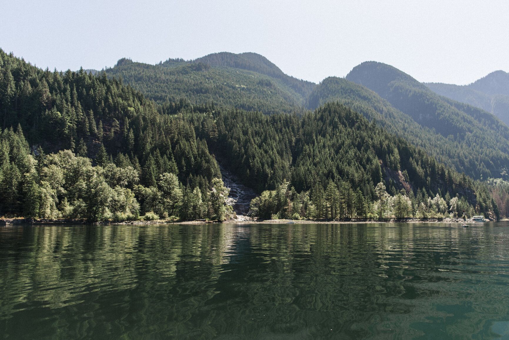 View from the water of Granite Falls, mountains, and forests along Indian Arm. Say Nuth Khaw Yum Park.