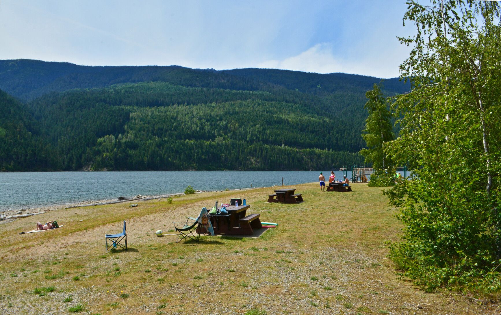 Park visitors relaxing at a day-use site by Lake Revelstoke in Martha Creek Park.