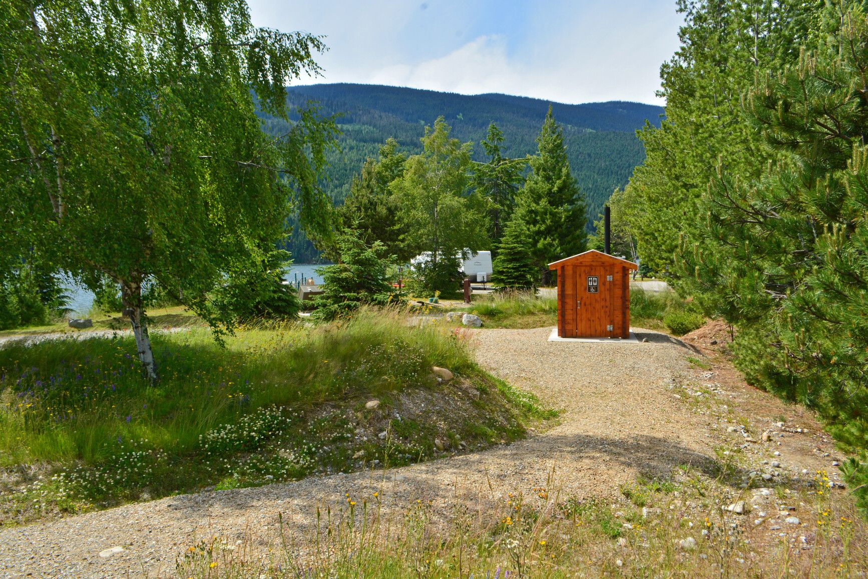 A gravel path leading to a pit toilet at the campground in Martha Creek Park.