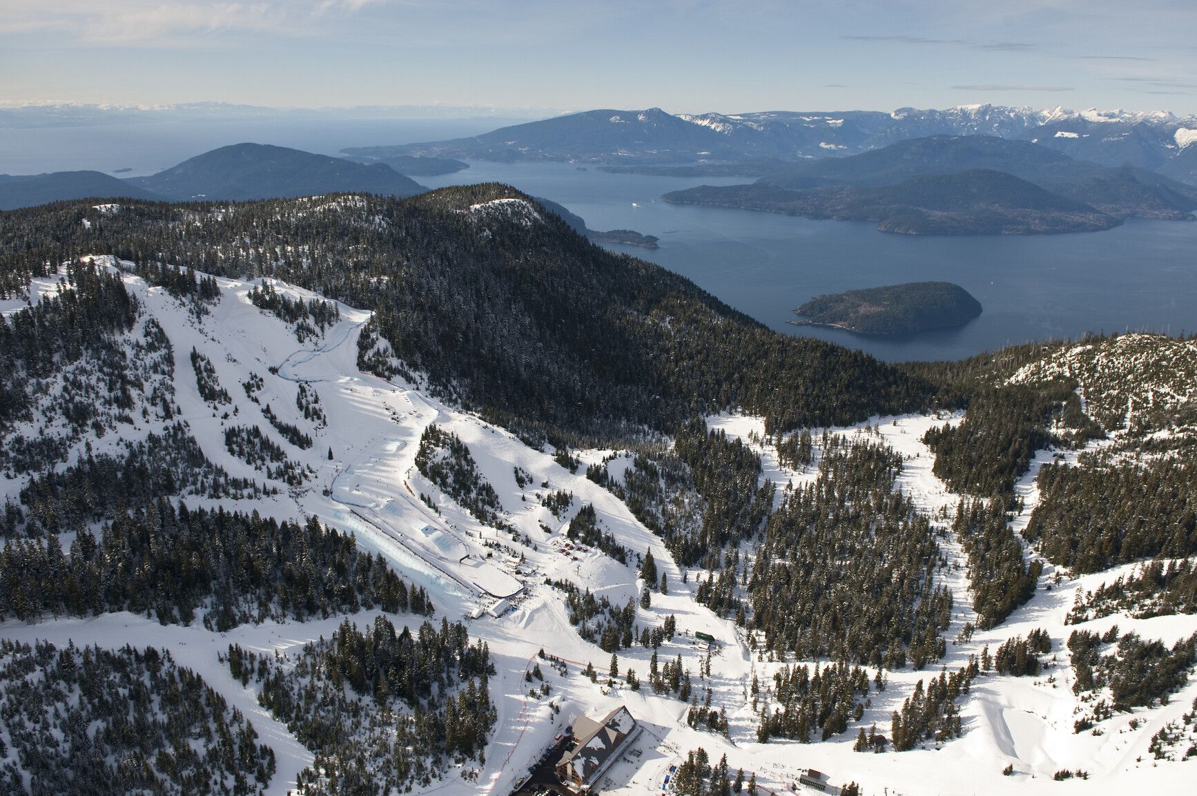 Aerial view of Cypress Mountain including the half pipe, &nbsp;ski cross, and snowboard cross track. The ocean and Howe Sound in the background. Credit Destination BC.
