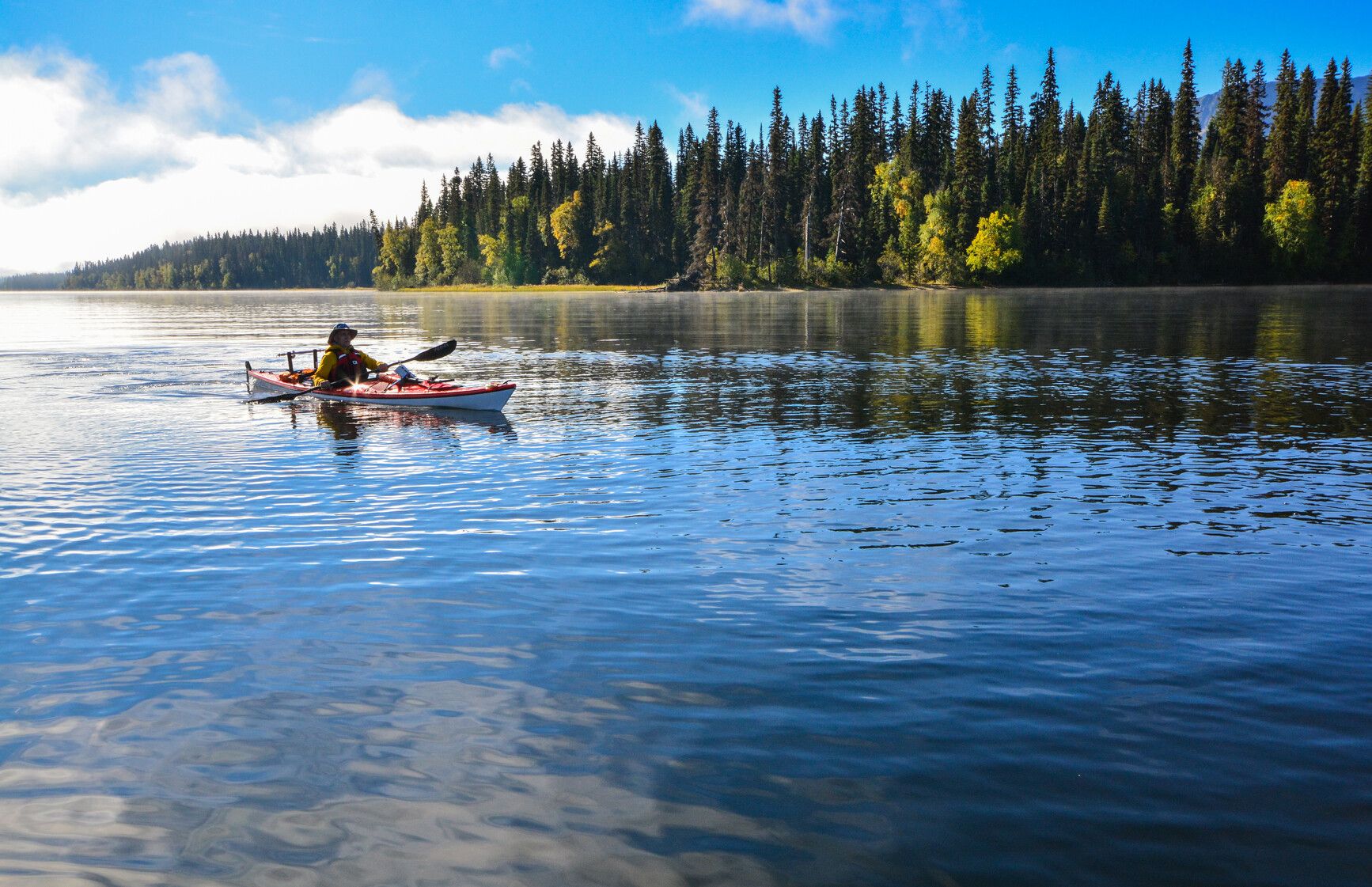 Exploring the serene waters of Spectacle Lakes by canoe in Bowron Lake Park.