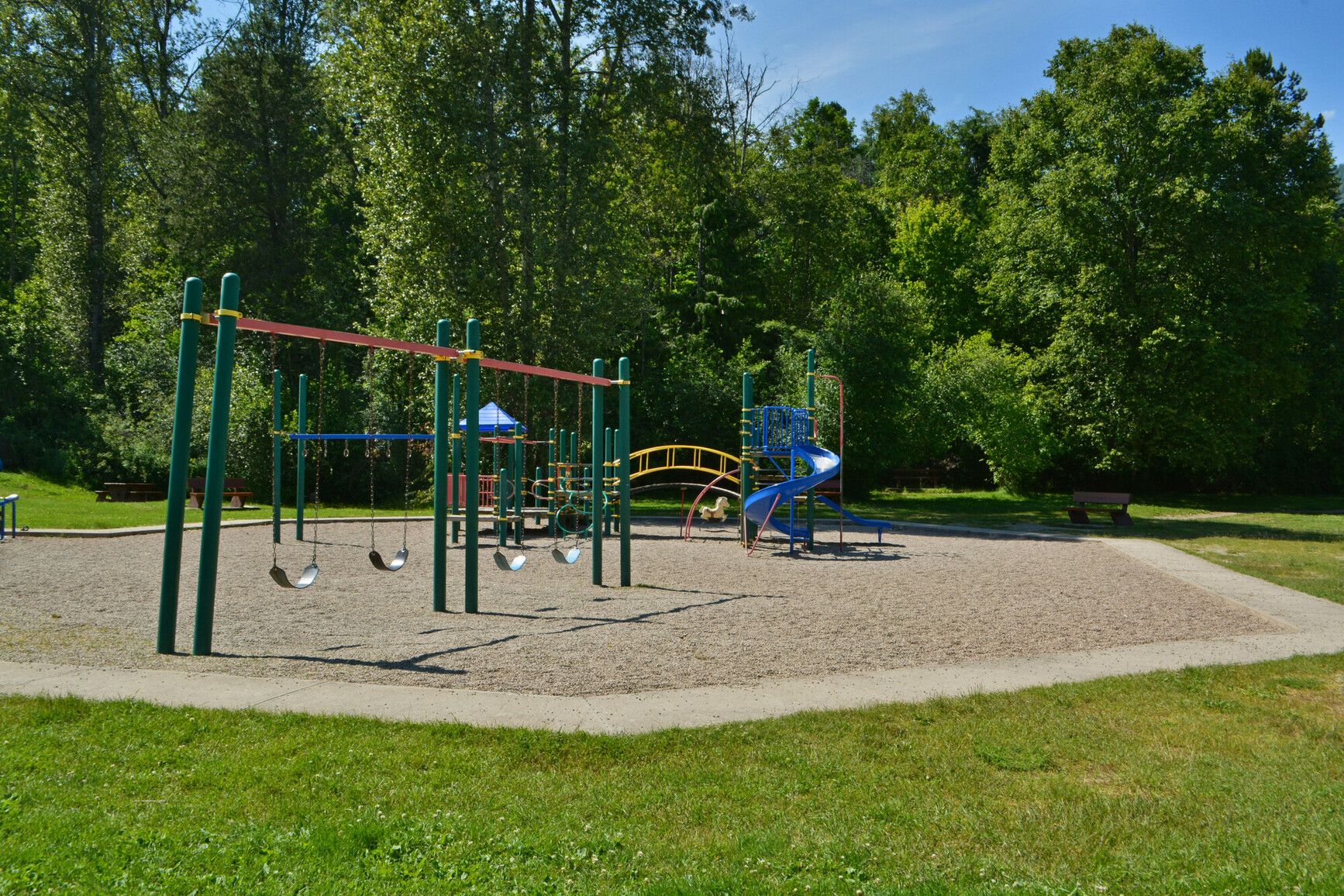 Experience the joy of Kokanee Creek Park's playground at the edge of the forest.