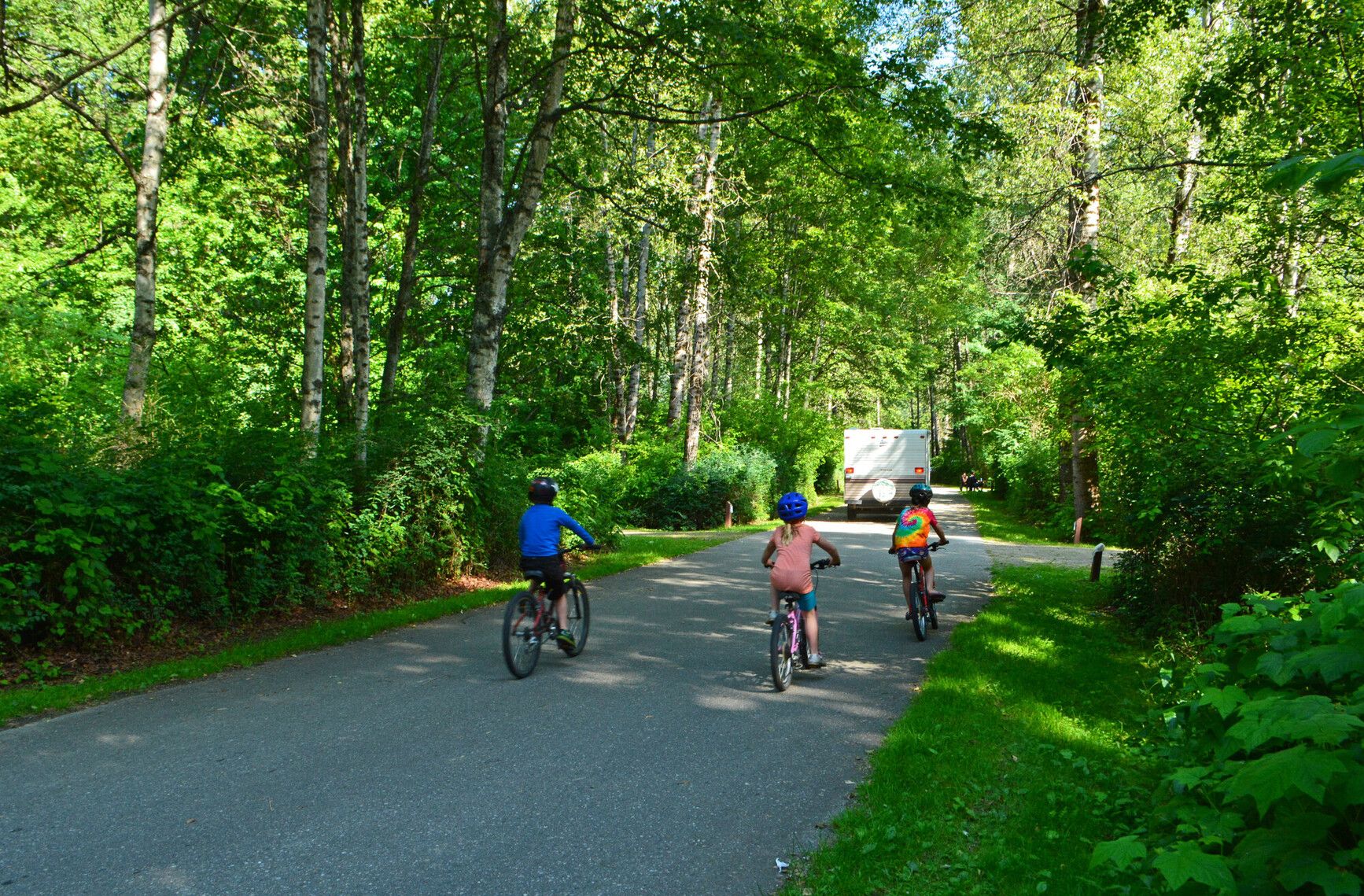 Young adventurers pedalling through Kokanee Creek Park's campsite roads, savouring the freedom of exploration.