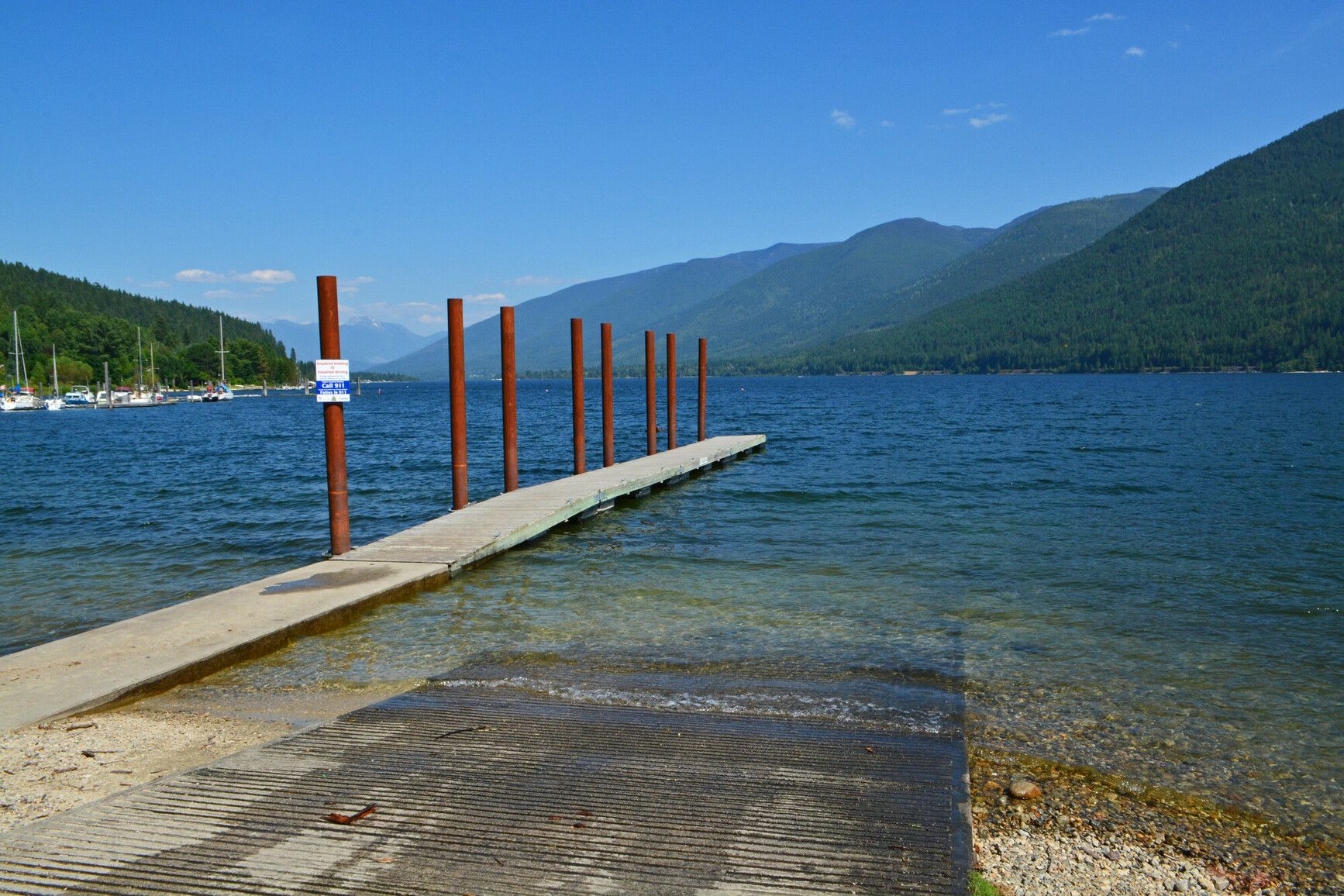 Boat launch and dock at lake with view of mountains in the background, Kokanee Creek Park.