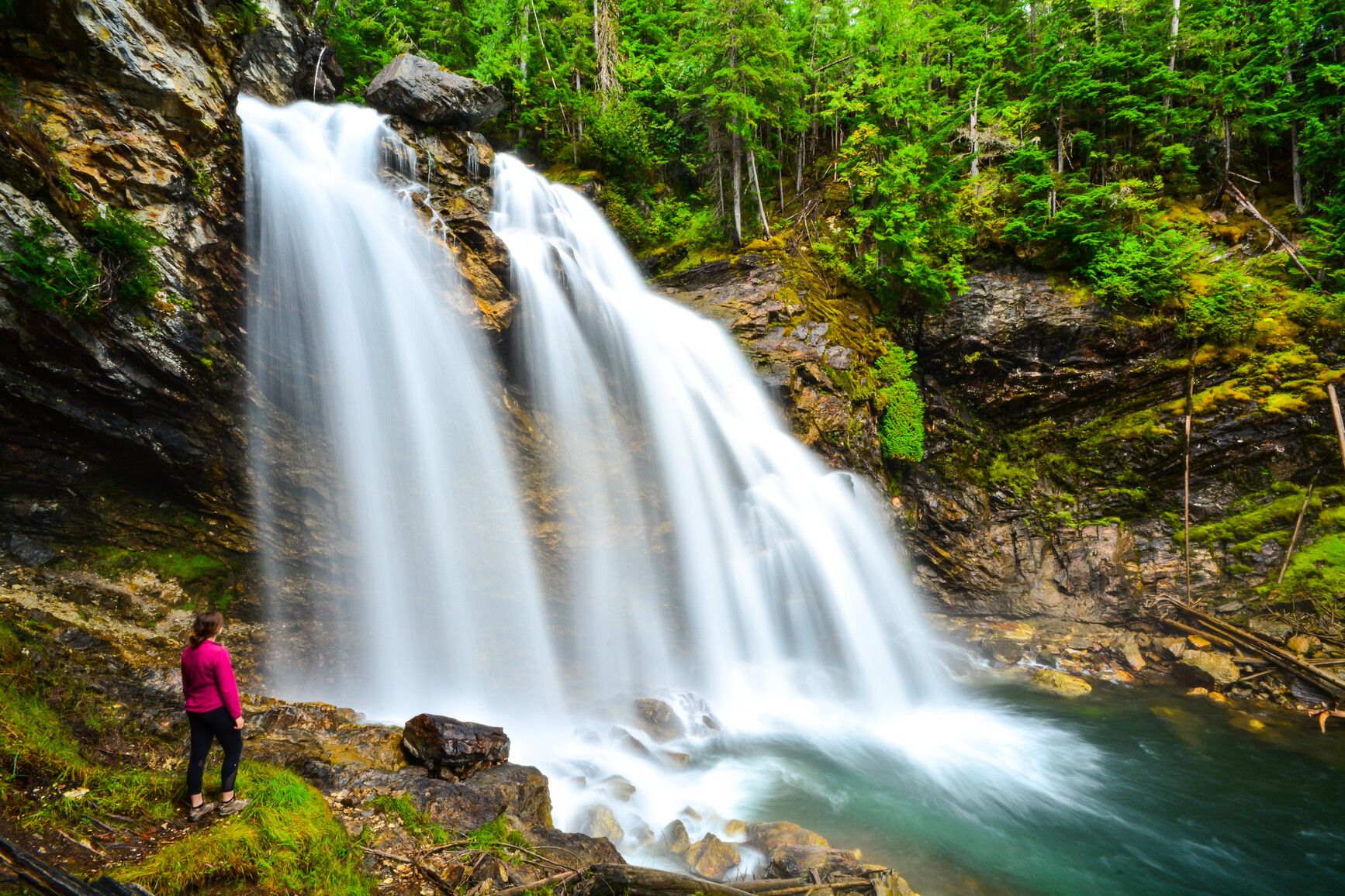 A park visitor takes in the scenic view from the base of Rainbow Falls, Monashee Park.