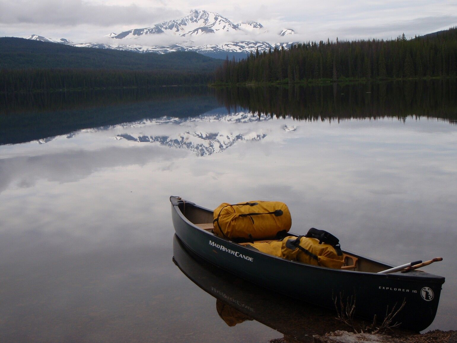 A loaded canoe on the shores of Stepp Lake with Mount Ney in the distance. Neneikekh/Nanika-Kidprice Park.