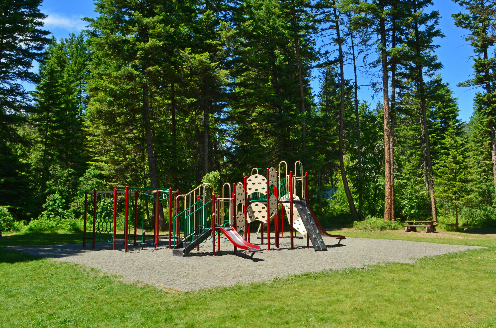 Playground and picnic table by the forest in the park.