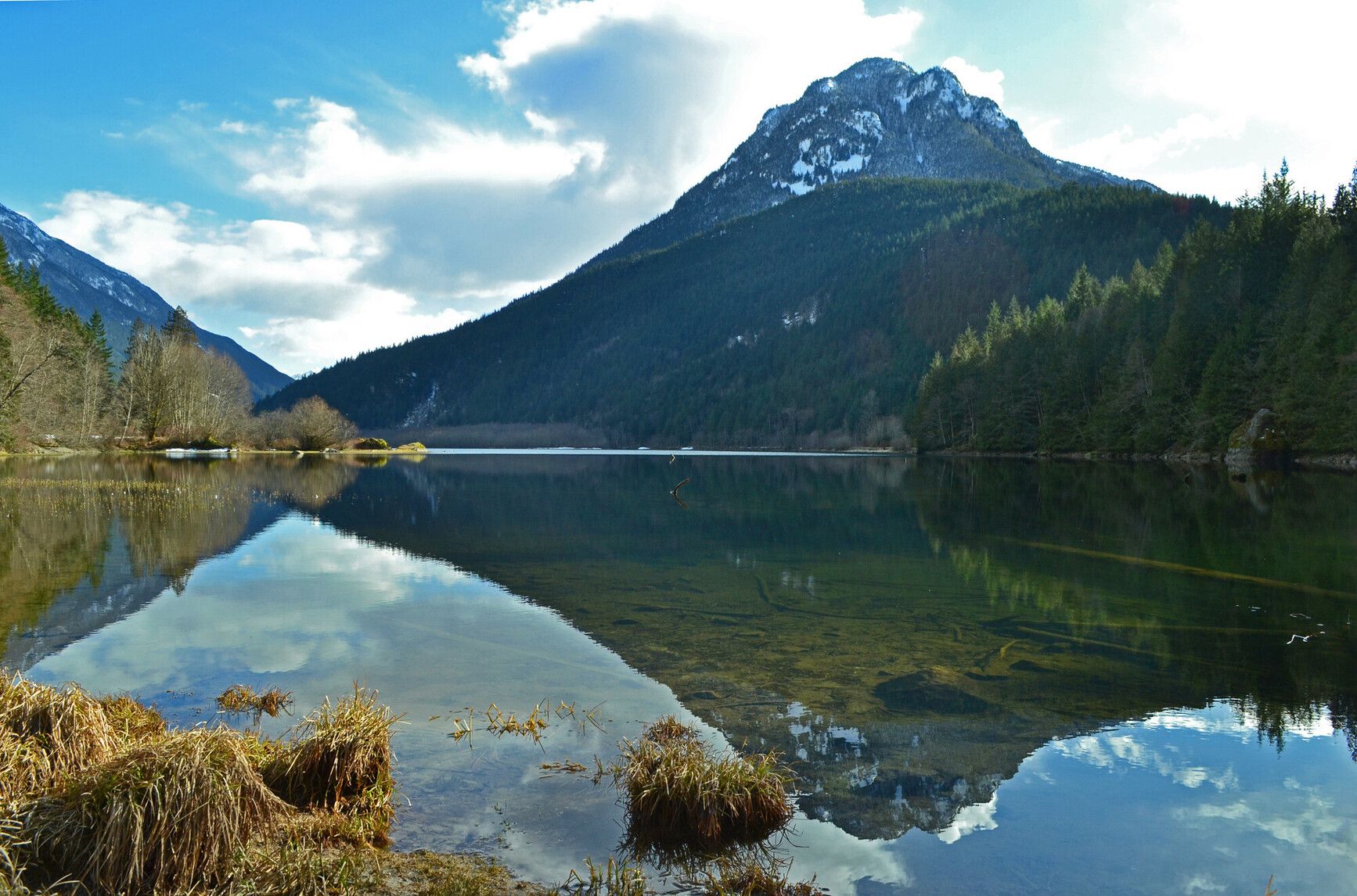 Mountains and forests surround the lake, reflecting on its still surface at Silver Lake Park
