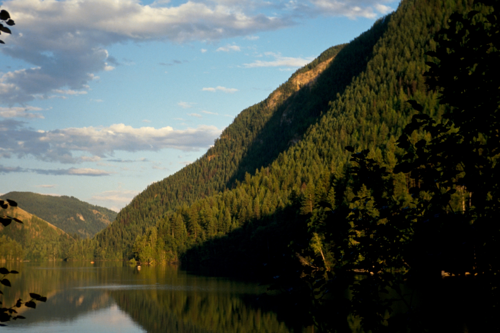 View of Echo Lake during golden hour, with the mountain and forests in the nearby distance.
